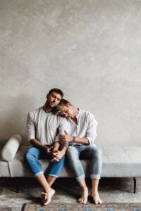 Michael and Tim Overdick are sitting on a couch and cuddling.