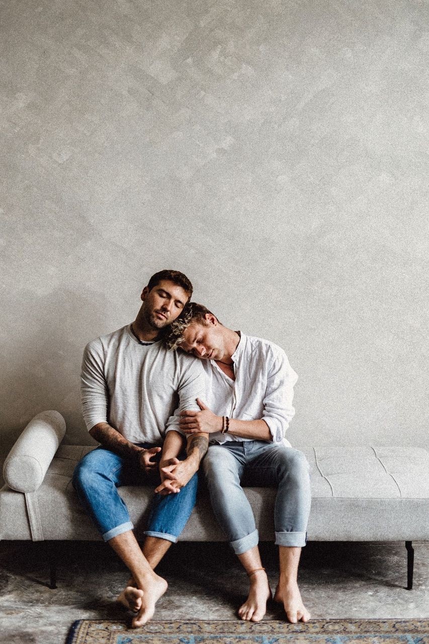 Michael and Tim Overdick are sitting on a couch and cuddling.