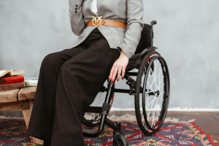 Das Foto zeigt den Unterkörper einer Frau, die im Rollstuhl sitzt.
