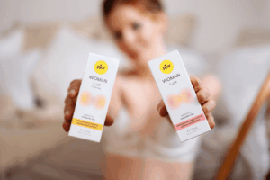 Woman holds the two pjur products, pjur WOMAN Lust and pjur WOMAN Lust Intense, up to the camera.