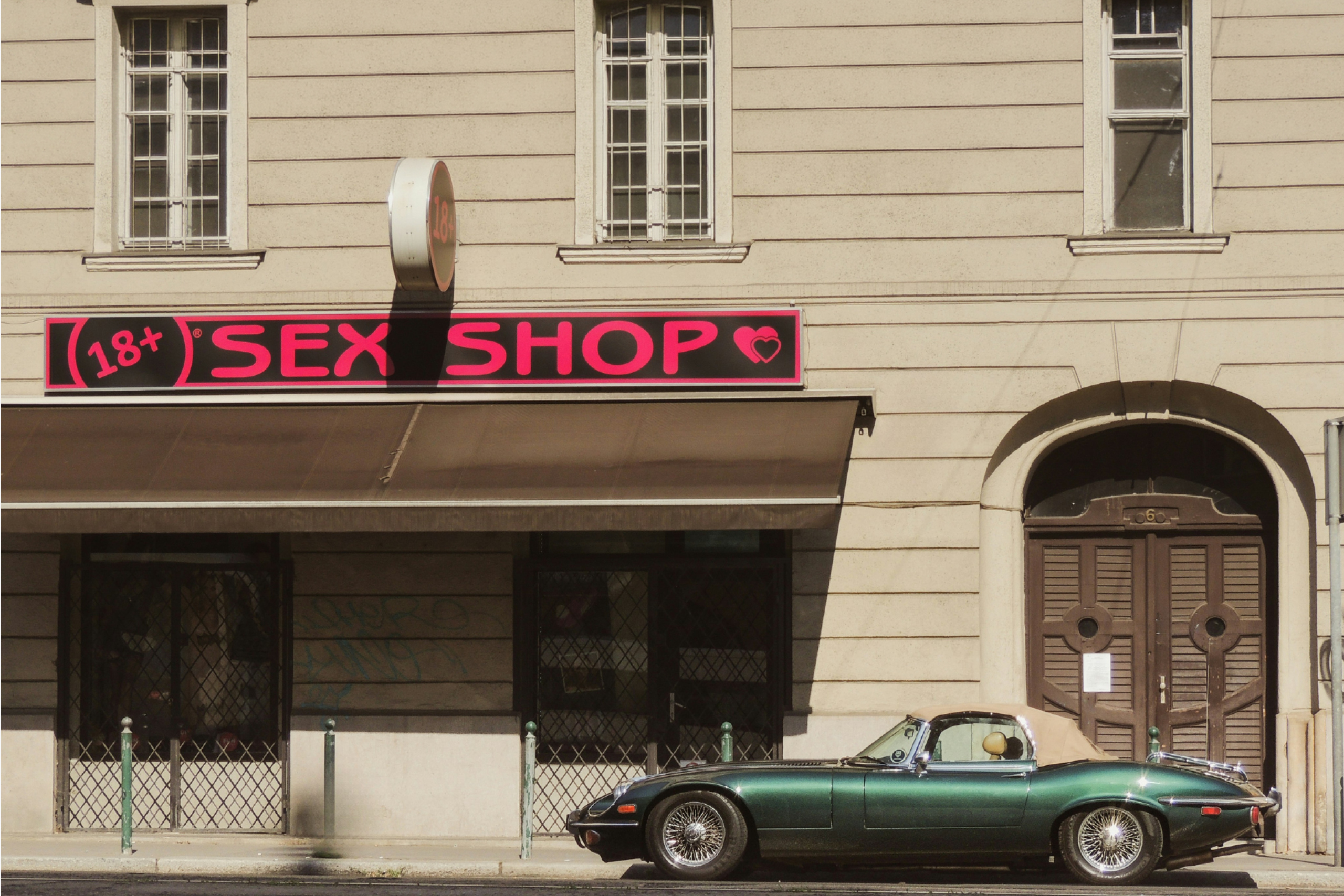Image of an adult store on a street, located in a light stone building